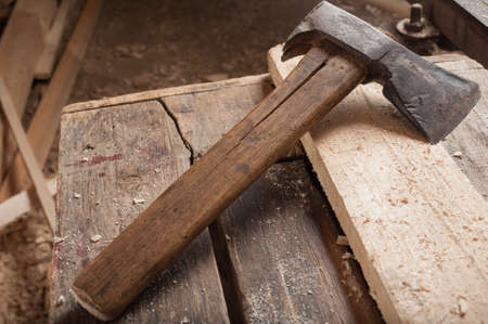 Old ax or hatchet on a wooded table in a carpenter workshopの写真素材