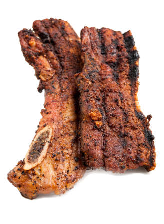 Pork meat fried on grill sitting isolated on white plateの写真素材