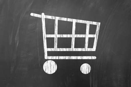 White shopping cart symbol on blackboardの写真素材