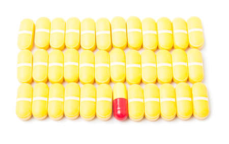 One pill standing out from the others. Medical concept isolated on white backgroundの写真素材