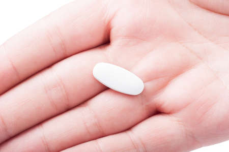 Closeup with one white pill on a man palm