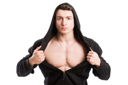 Young and handsome male wearing black hoodie and uncovering his muscular chestの写真素材
