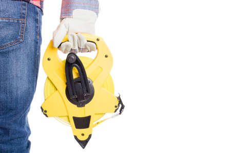 Construction worker holding an industrial measuring reel near the legの写真素材