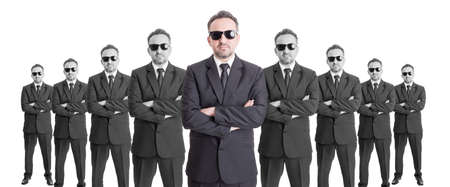 Team of confindent business people or special agents with arms crossed on wide image. Leader conceptの写真素材