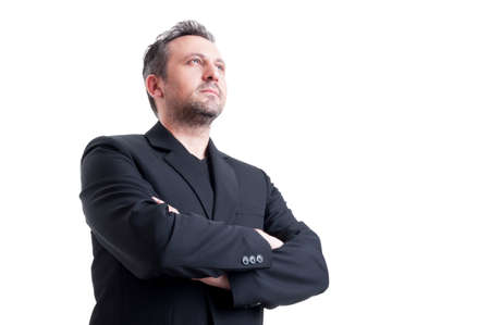 Confident and visionary business man posing from low angle looking up with arms crossedの写真素材