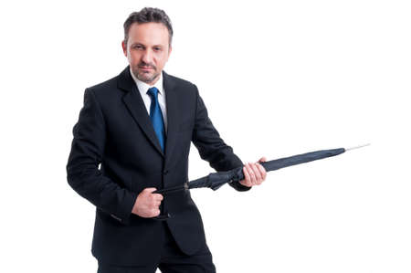 Powerful and dangerous business man holding an umbrella like a riffle or gunの写真素材