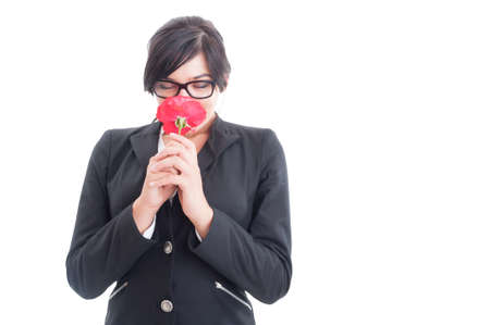 Happy business woman smelling a red flower. Romantic lady inlove conceptの写真素材
