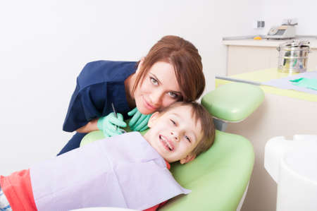Happy child in dental office or at dentist. Friendly and careful woman doctorの写真素材