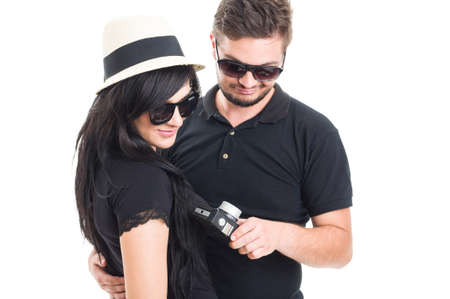 Couple holding an old vintage or retro photo camera feeling disappointedの写真素材