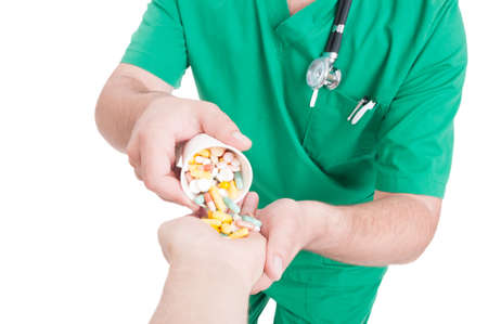 Doctor, medic or pharmacist pouring pills in patient hand on from plastic cup as daily dose
