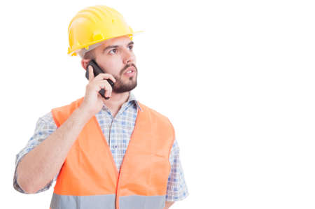 Smart, young and modern engineer talking on smartphone while looking up