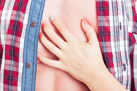 Sexy female hand touching man chest with open shirt. Passion and sensuality conceptの写真素材