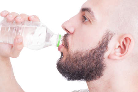 Close up with guy drinking water from plastic bottle. Summer heat and hydrating concept