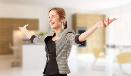 Excited real estate agent or broker with arms wide open on house indoor backgroundの写真素材