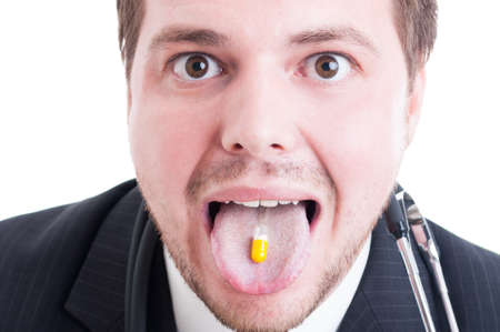 Male doctor or medic taking a pill on tongue. Closeup of medicine abuse concept