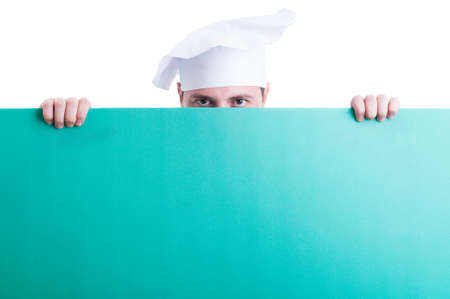 Cook and chef looking over green wall or board with green advertising spaceの写真素材