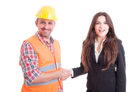 Smiling contractor and business woman shaking hands  as successful partnership and teamwork concept...