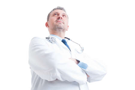 Hero shot in low angle of young doctor or medic standing confident with arms crossed isolated on white backgroundの写真素材