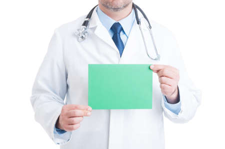Anonymous doctor or medic holding green blank paper with copy space and advertising areaの写真素材