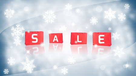Winter sale offer concept with shopping bags on blue background and snowflakesの写真素材
