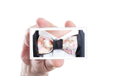 Hand holding card with bowtie picture as bow tie fashion conceptの写真素材