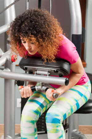 Woman bending and doing abdominal training in the gym