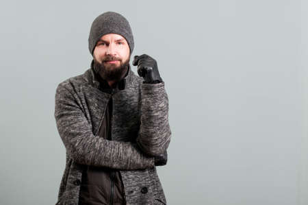 Portrait of handsome bearded  man wearing black leather gloves isolated on grey backgroundの写真素材