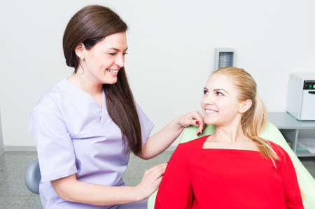 Friendly and trustworthy dentist woman and patient smiling relaxed and confidentの写真素材