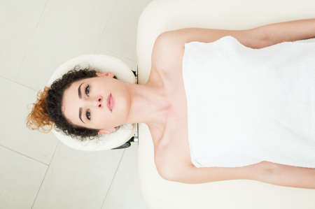 Beautiful woman lying and relaxing on massage table in the beauty and spa centerの写真素材