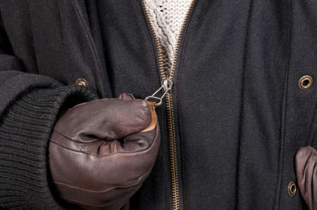 Closeup texture of open zipper jacket hold with leather gloves by man as winter outfit
