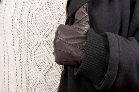 Close-up of man leather glove, black jacket and knitted sweater as winter clothes outfit concept