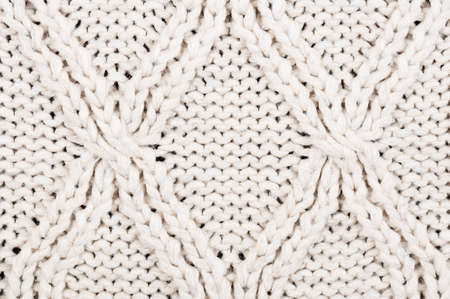 Close-up of beige knitted winter sweater with pattern as textured material concept