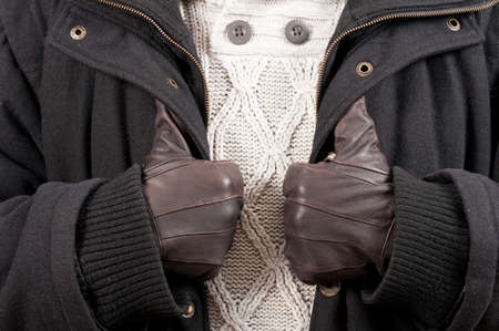 Man in winter clothes holding his jacket in close-up picture as modern outfitの写真素材