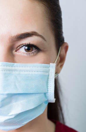 Female doctor half face or medical concept on gray backgroundの写真素材