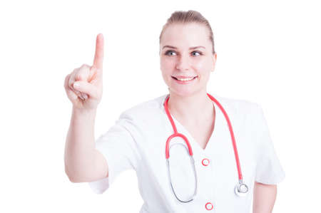 Smiling young doctor pointing  or touching imaginary button and wearing medical unifrom isolated on white backgroundの写真素材