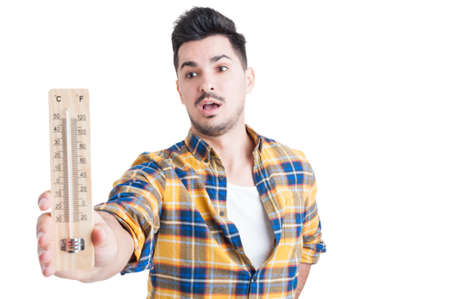Man in shirt holding a thermometer in his hand and looking amazed because of high temperature...