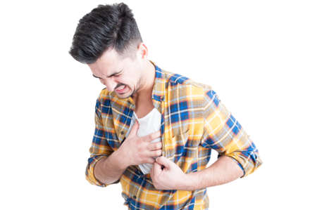 Young man holding hand to his chest during heart attack and palpitations isolated on white backgroundの写真素材