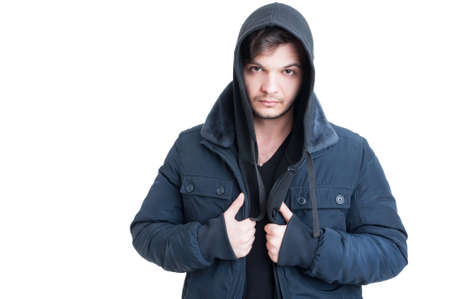 Portrait of young man wearing black hooded sweatshirt and jacket as urban outfit concept isolated on...