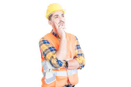 Young construction worker or engineer thinking and looking away while meditate at something isolated on whiteの写真素材
