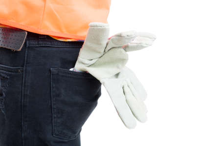 Engineering equipment concept in close-up with gloves and orange vest in male jeans pocket isolated on whiteの写真素材