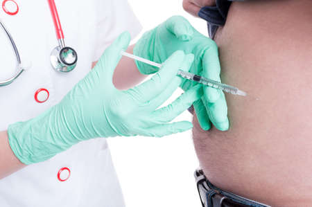 Female doctor making injection in abdomen to a diabetes patient as insulin dependent concept isolated on whiteの写真素材