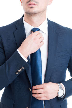 Salesman or broker fixing and adjusting his blue necktie concept on white backgroundの写真素材
