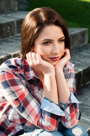 Close-up portrait of beautiful woman standing and relaxing in the park in summerの写真素材