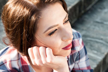 Close-up woman standing and looking away in the park in a warm spring dayの写真素材