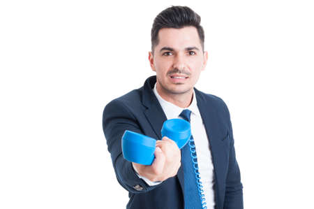 Portrait of attractive businessman holding retro telephone in his hand. This call is for you concept isolated on white backgroundの写真素材