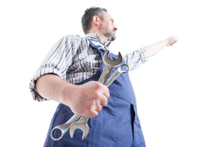 Hero shot with young mechanic pointing finger up and holding spaneer isolated on white background