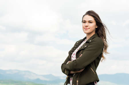 Portrait of beautiful smiling woman enjoying springtime outside on a sunny day with advertising areaの写真素材