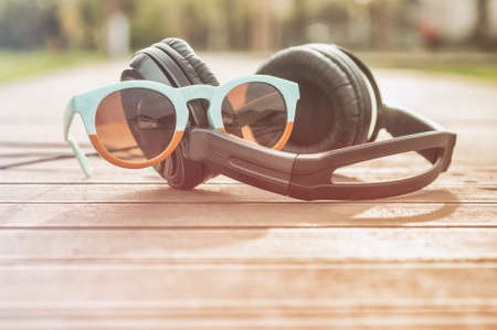 Outdoor close-up with trendy sunglasses and headphones as music and summer relaxation concept