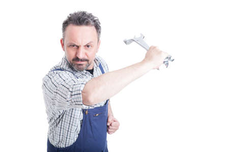 Angry mechanic in workwear acting violent with a steel wrench isolated on white background