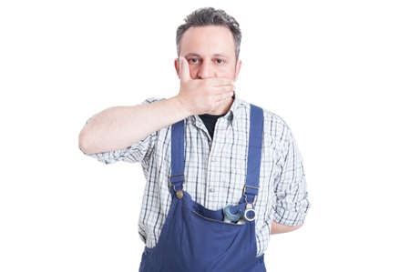 Handsome mechanic in the speak no evil pose as silence or speachless concept isolated on whiteの写真素材